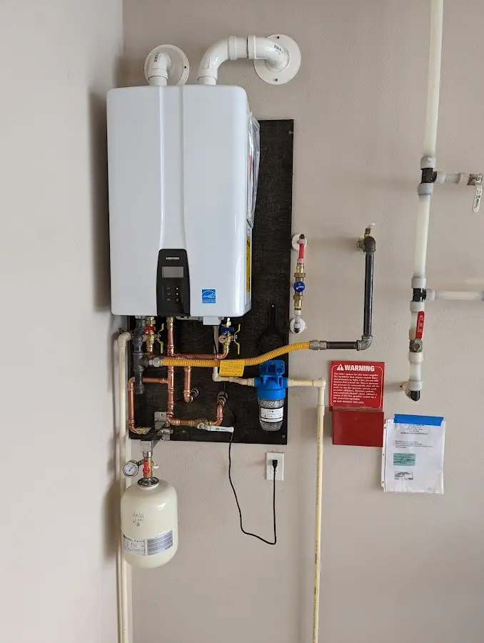 Professional plumber installing copper piping in a Revere home